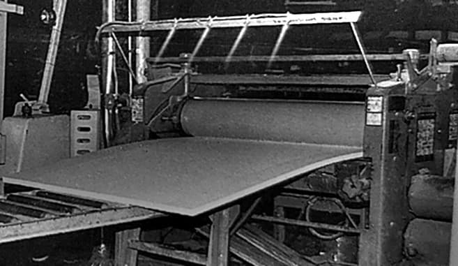 A faced sheet coming off the end of the line onto a roller table.