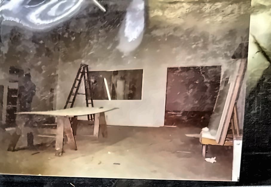 Finish work in a new room: a stepladder, a trestle and a long board against a finished wall.