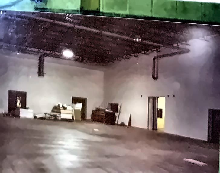 A completed processing room, walls finished, floor sealed, doors hung.