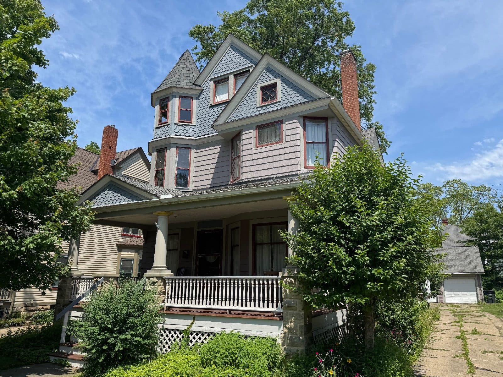 Before: the house from the front corner, the corner tower's windows in old red-trimmed sash, a diamond-paned window in the gable.