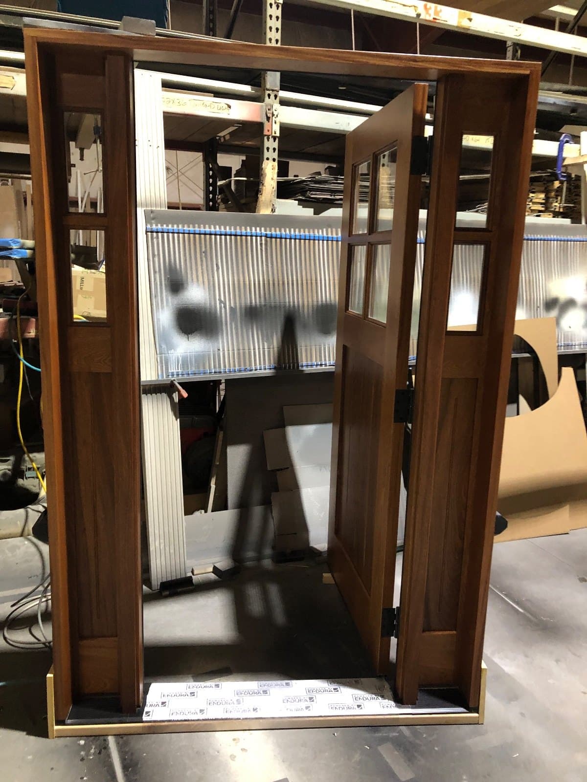 The same craftsman door with its two sidelites, seen at an angle across the shop floor.