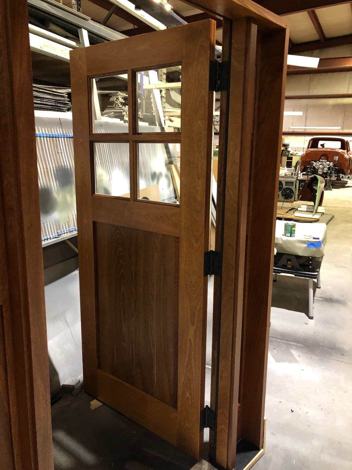A stained wood craftsman door and sidelite seen square on in the shop.