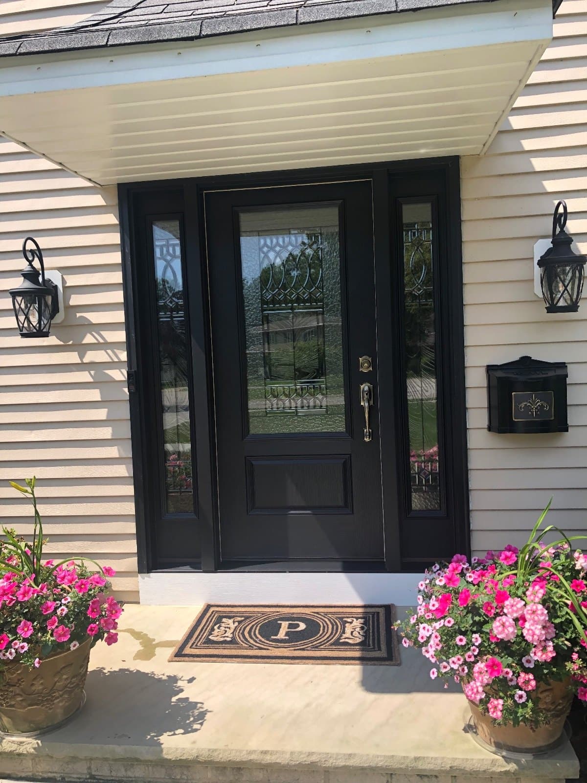 A black entry door with leaded sidelites, installed.