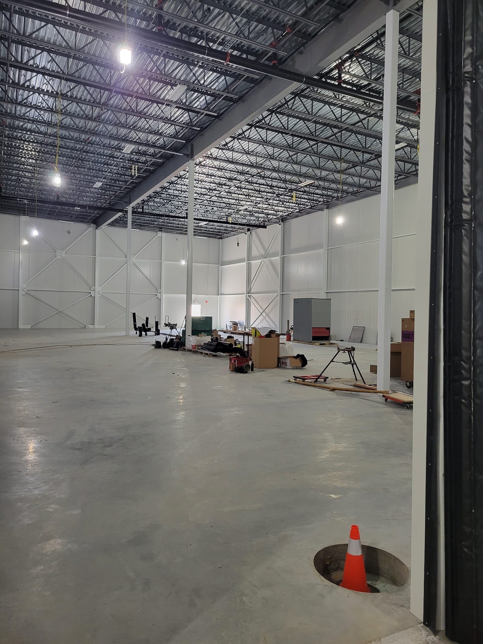 Freezer addition interior with panel walls set inside the structural steel and a lift in the corner.