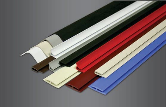 Lengths of vinyl panel molding in white, black, red, blue, brown and beige, fanned out to show each profile at its cut end.