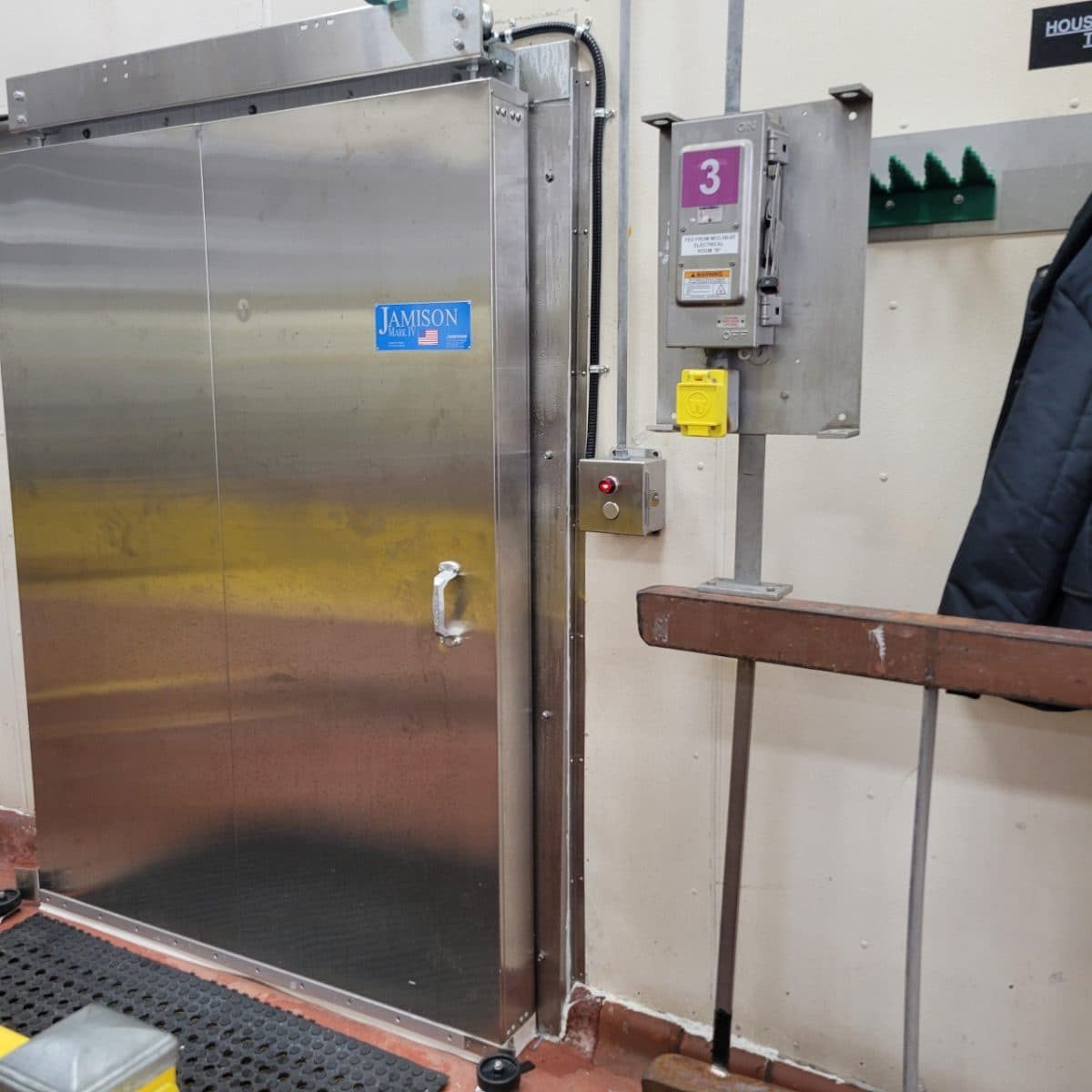 Stainless steel sliding freezer door on a spiral freezer line inside a food plant.