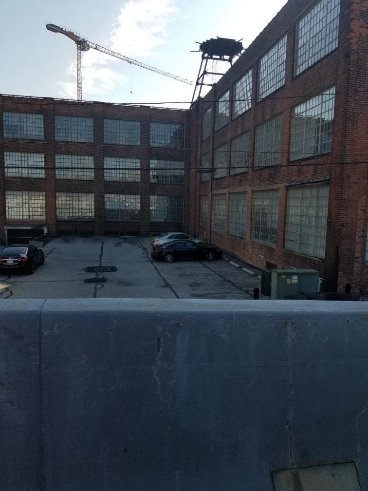 A brick industrial building around a courtyard, banks of steel windows across every floor.