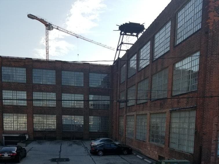 Before: the courtyard between two brick warehouse wings, banks of original steel windows in light frames on every floor, the water tower on the roof.