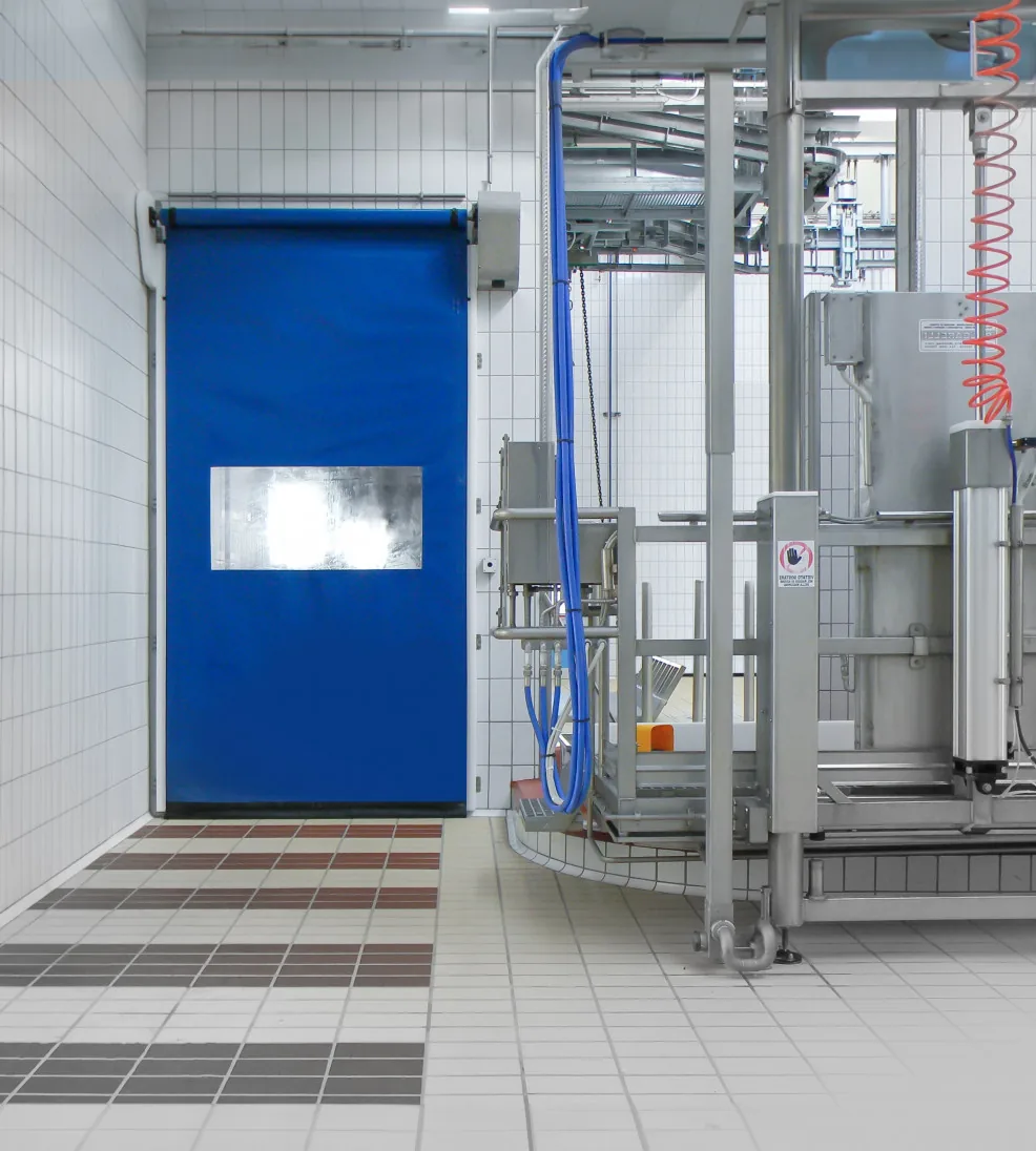 DynamicRoll Stainless high-speed door with a blue curtain in a tiled food-production room