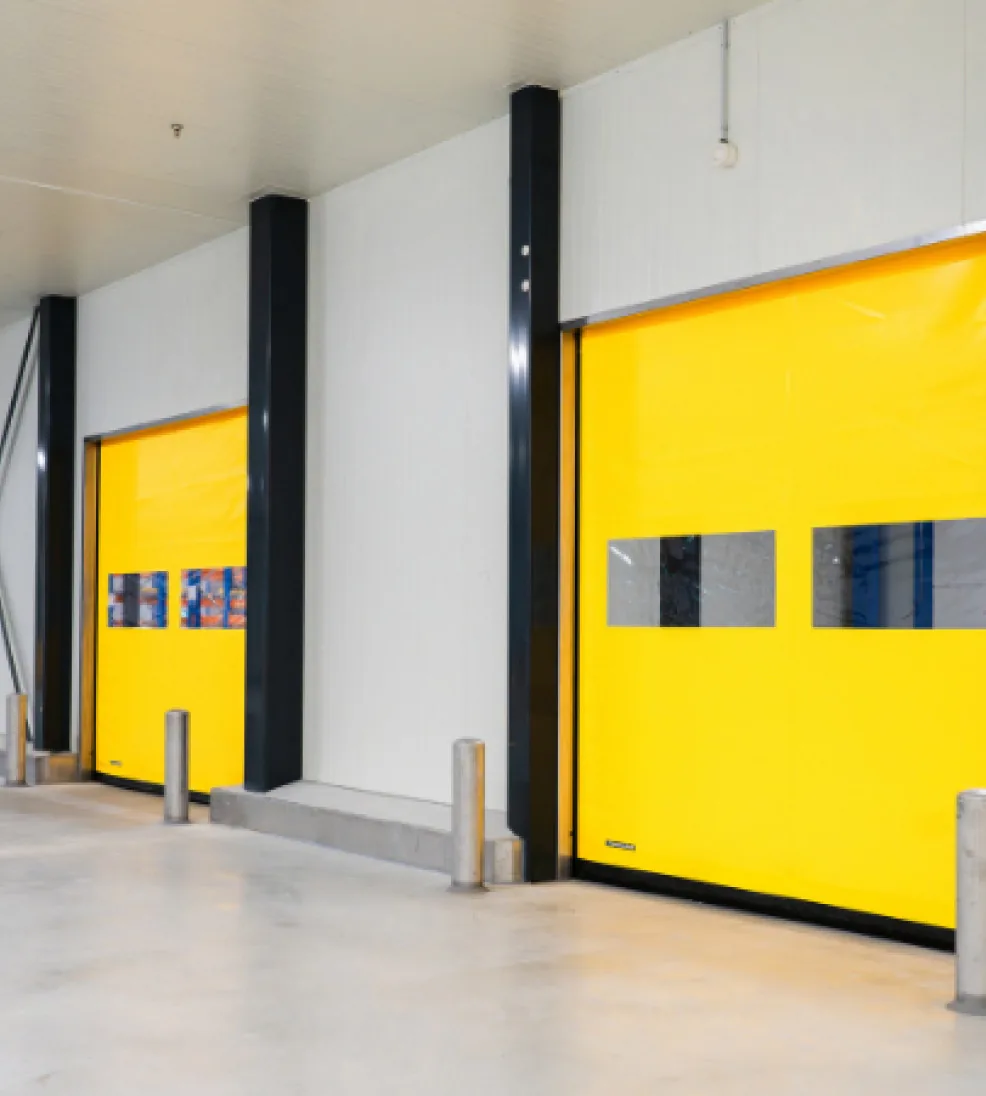 Two DynamicRoll Stainless high-speed doors with yellow curtains in a production hall