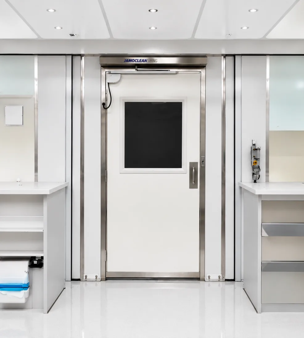 Jamoclean swing cleanroom door with a vision panel between cleanroom casework