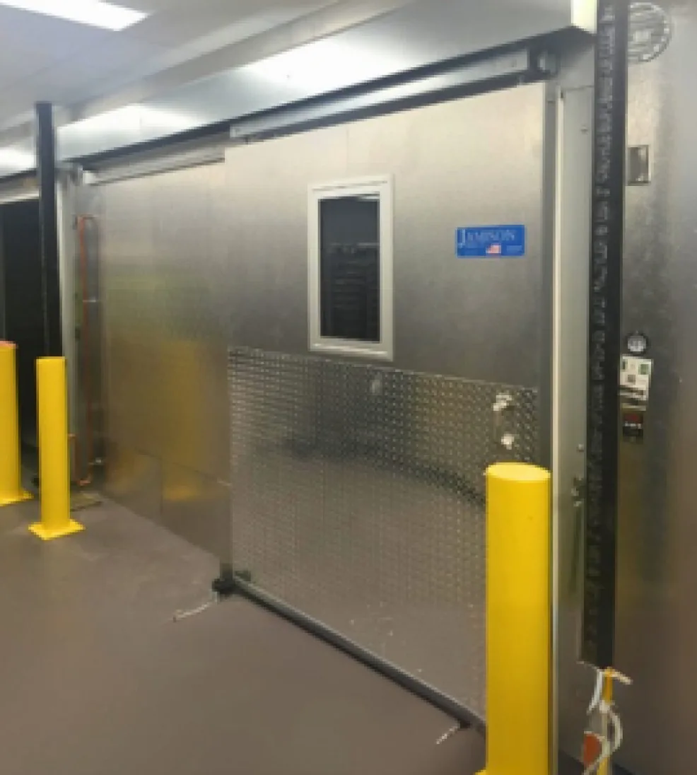 Stainless Jamoglide sliding door with a vision window and diamond-plate lower panel, partly open