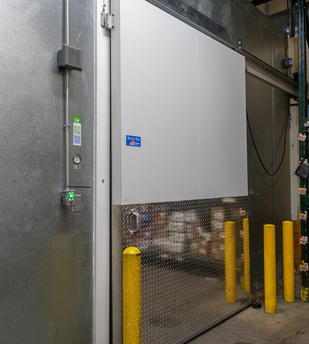 Jamoglide Retail sliding freezer door, open, with a diamond-plate lower panel and guard posts