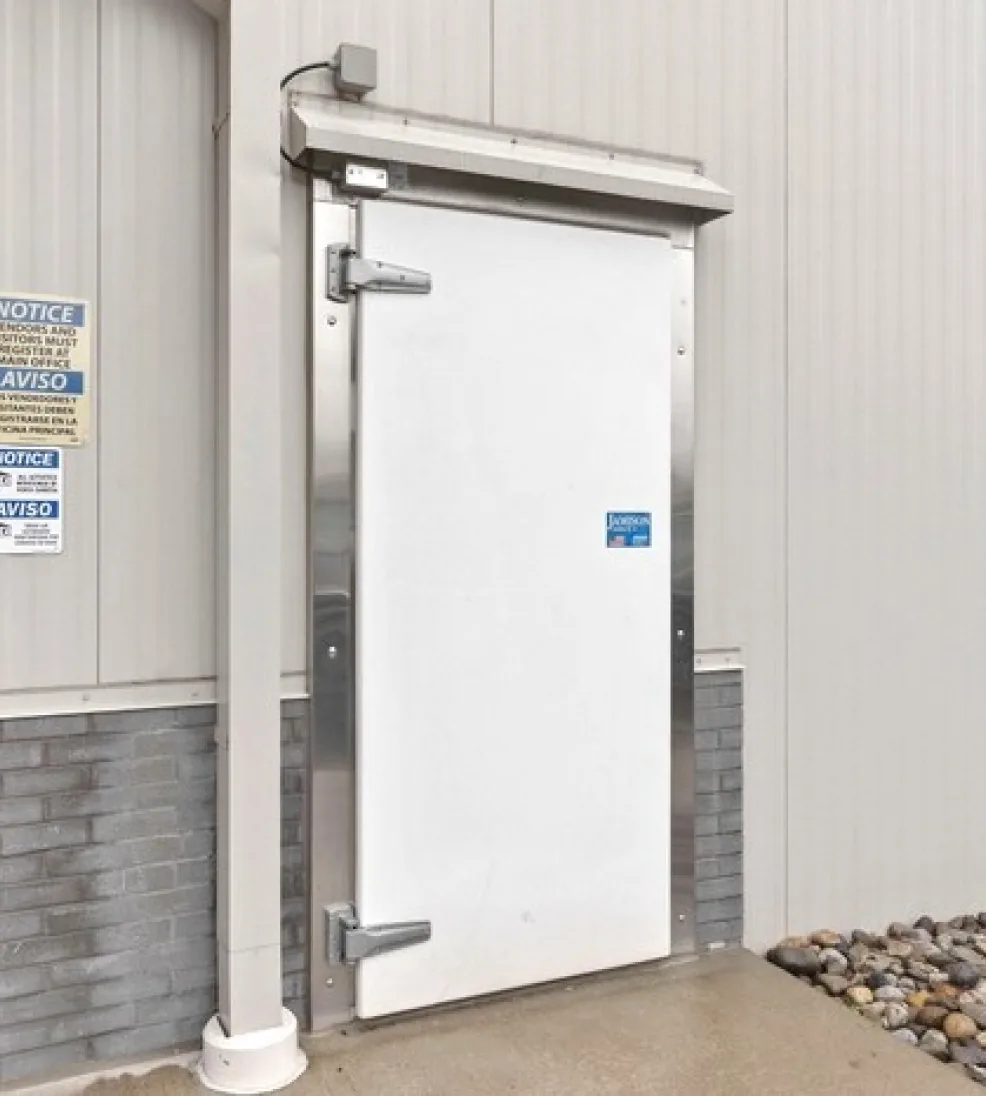 White Jamolite II fiberglass swing freezer door with a stainless steel frame and hood at grade