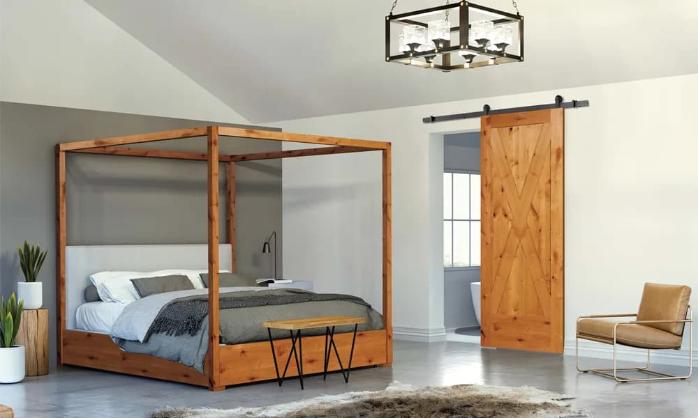 A natural wood plank barn door hung on a black sliding track beside a bedroom