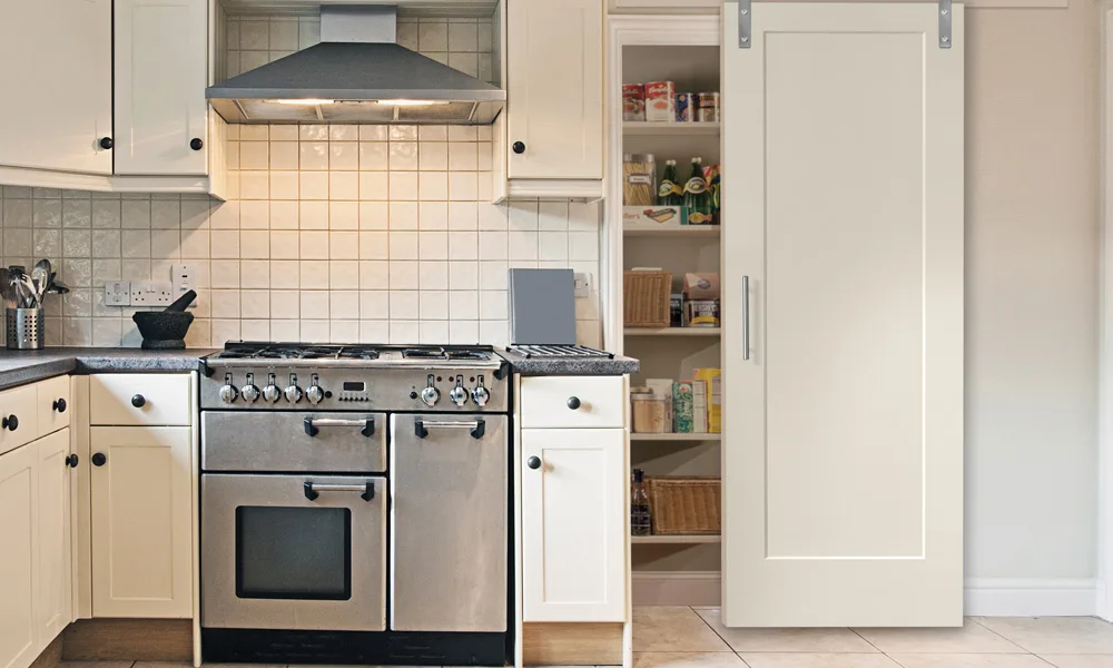A white single-panel barn door closing a kitchen pantry