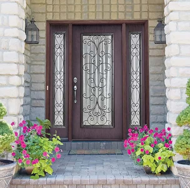 A dark wood-tone entry door with scrolled decorative glass and two sidelites
