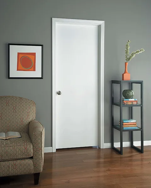 A white primed flush interior door in a gray room