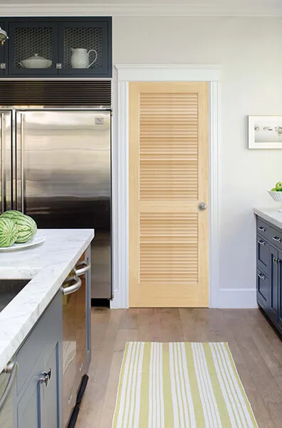 A natural pine full-louver door in a kitchen