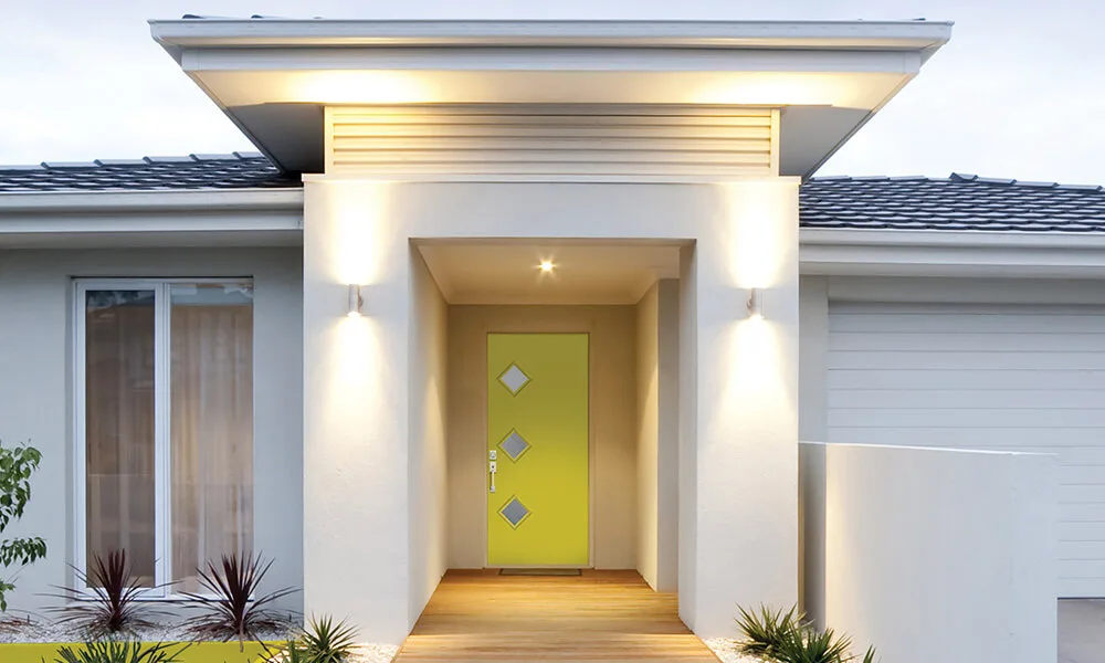 A lime green modern entry door with small square lites on a white house