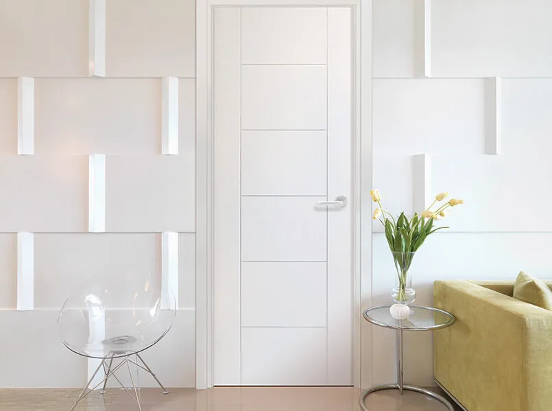 A white molded interior door with grooved horizontal lines in a white room
