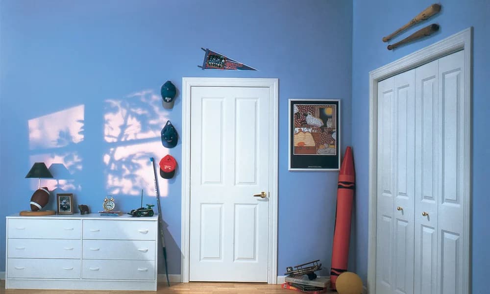 A white molded door and a molded bifold in a blue bedroom