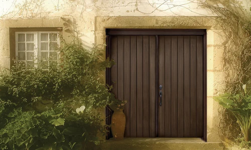 A dark stained double panel entry door in a stucco wall