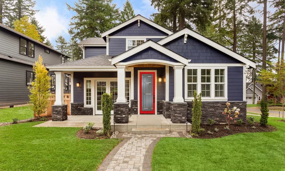 A red entry door on a gray craftsman house