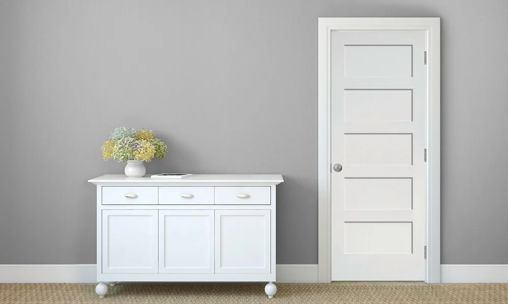 A white five-panel shaker door beside a white sideboard