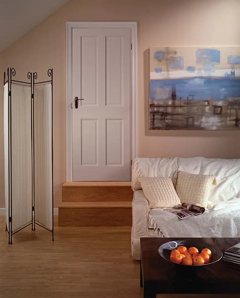 A white four-panel door at the top of a step