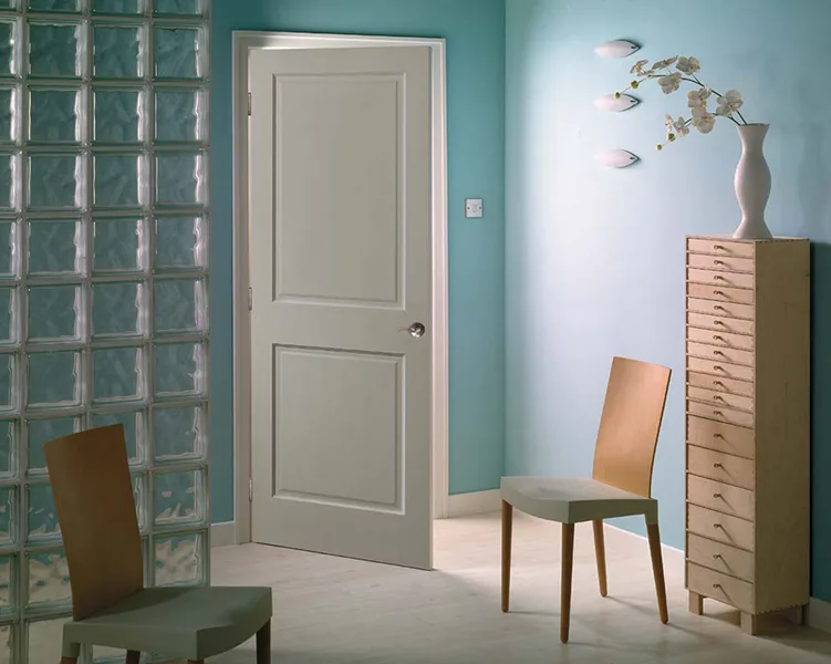 A two-panel door in a teal room with a glass block wall
