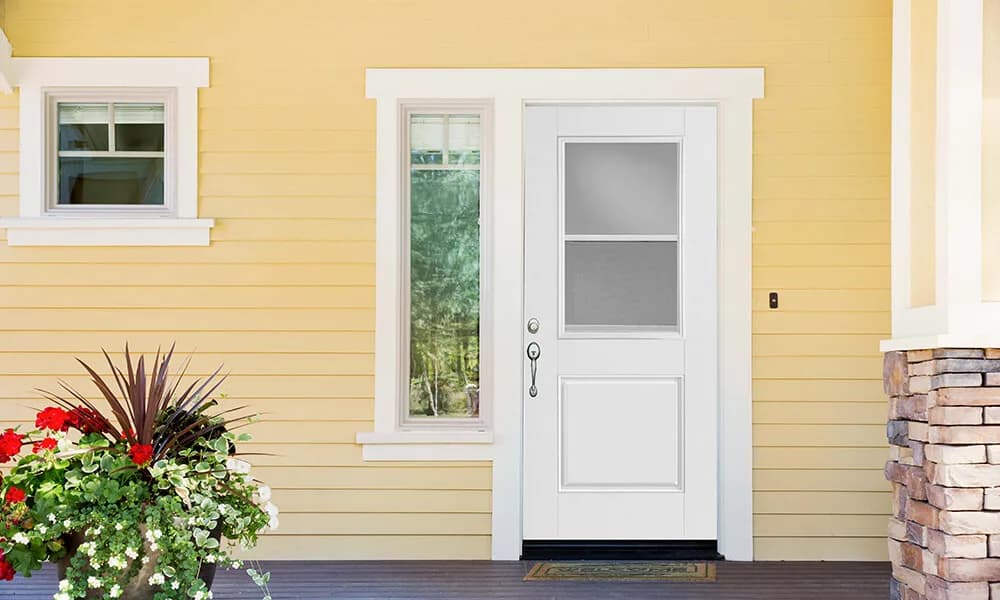 A white entry door with a vent lite in its upper half and a sidelite on a yellow house
